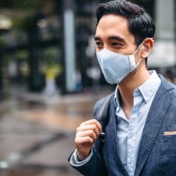 Businessman wearing mask in city