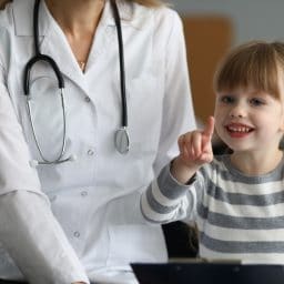 A doctor sits with a girl.