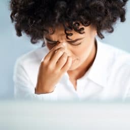 Close-up of a woman experiencing sinus pressure.