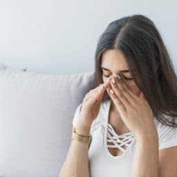 Sinus ache causing very paintful headache. Unhealthy woman in pain. Sharp strong sore. Sinus pain, sinus pressure, sinusitis. Sad woman holding her nose and head because sinus pain