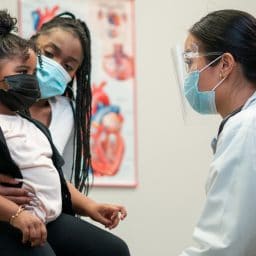 Mom and daughter visiting with an ENT doctor in a clinical setting.