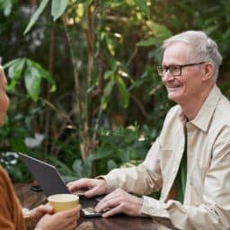 Older couple enjoying a conversation at an outdoor cafe.