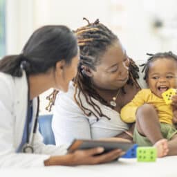 Young boy and mother talking to the doctor at his appointment